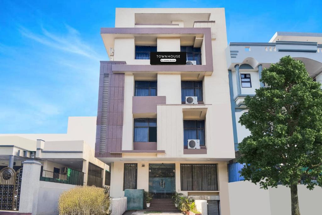 un alto edificio bianco con un cartello sopra di Super Townhouse Malviya Nagar Near Airport Formerly Royal Residency a Jaipur