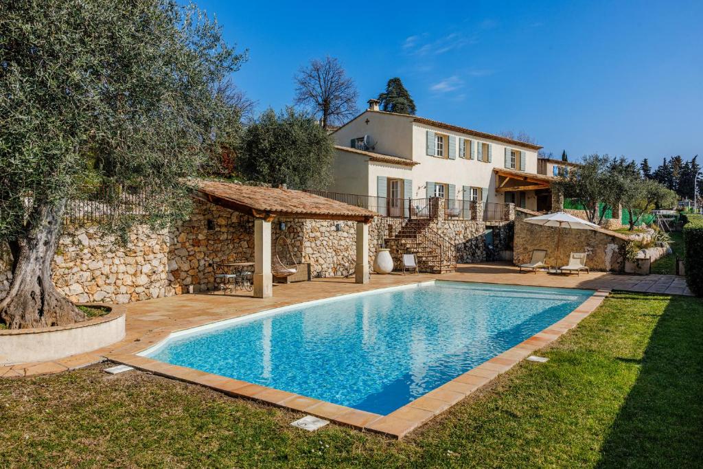 a swimming pool in front of a house at Mas Gauda in La Gaude