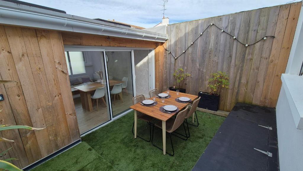 une terrasse avec une table en bois et une clôture en bois dans l'établissement Maison plein centre ville à 100 m de la plage, à Saint-Georges-de-Didonne