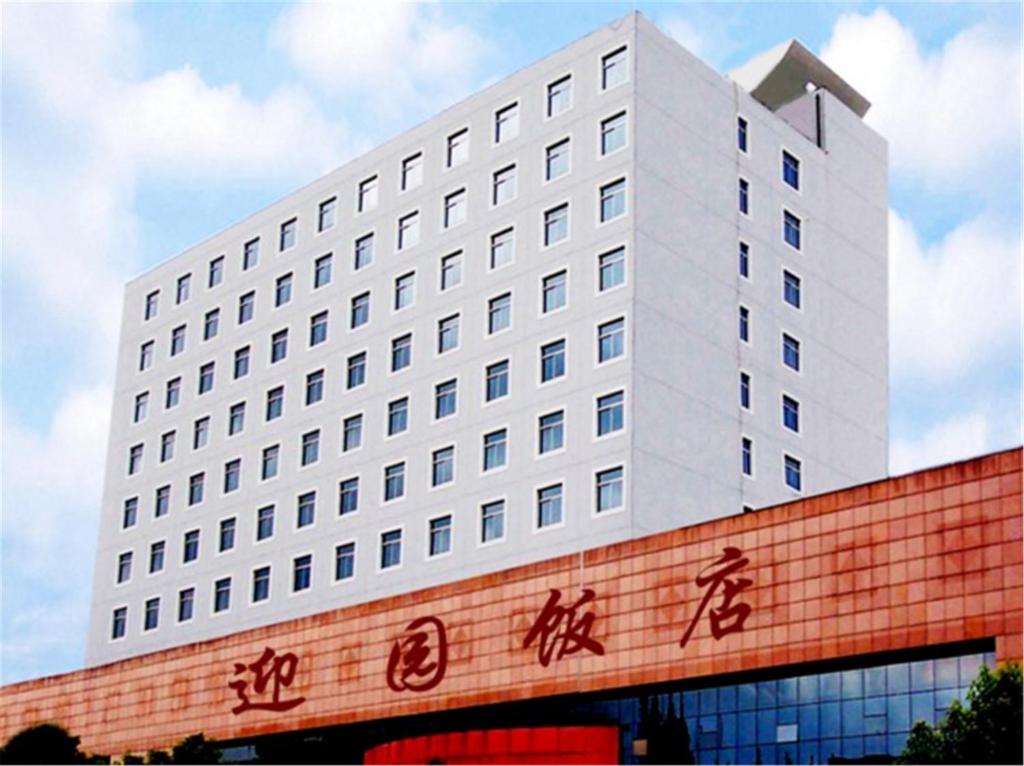 un edificio blanco con escritura a un lado. en Ying Yuan Hotel, en Jiading