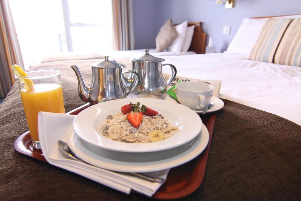a breakfast tray with a plate of food on a bed at The Riviera Hotel & Apartments - Alum Chine in Bournemouth
