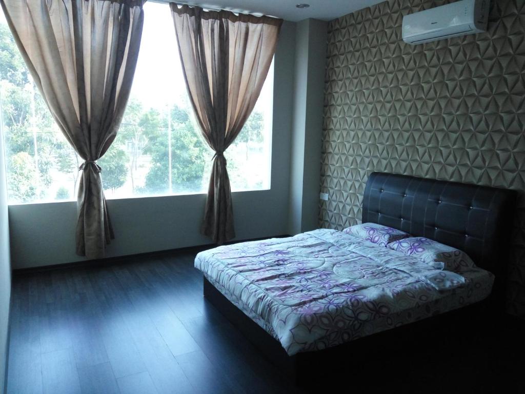 um quarto com uma cama em frente a uma janela em Vista Vacation Homestay em Malaca