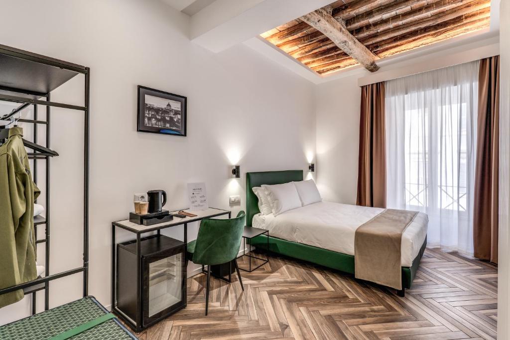 a bedroom with a bed and a desk and a window at Effe Luxury Rooms in Rome