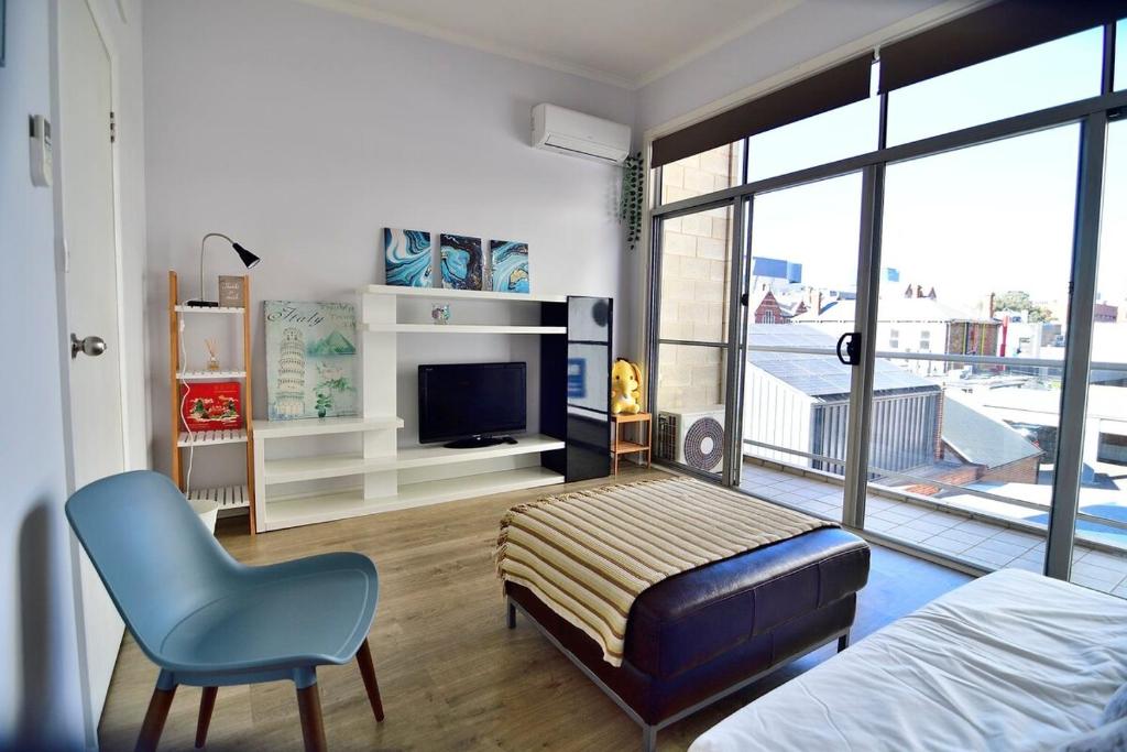 a bedroom with a bed and a chair and a fireplace at 3-Bedroom Townhouse in Heart of Adelaide with Parking in Adelaide