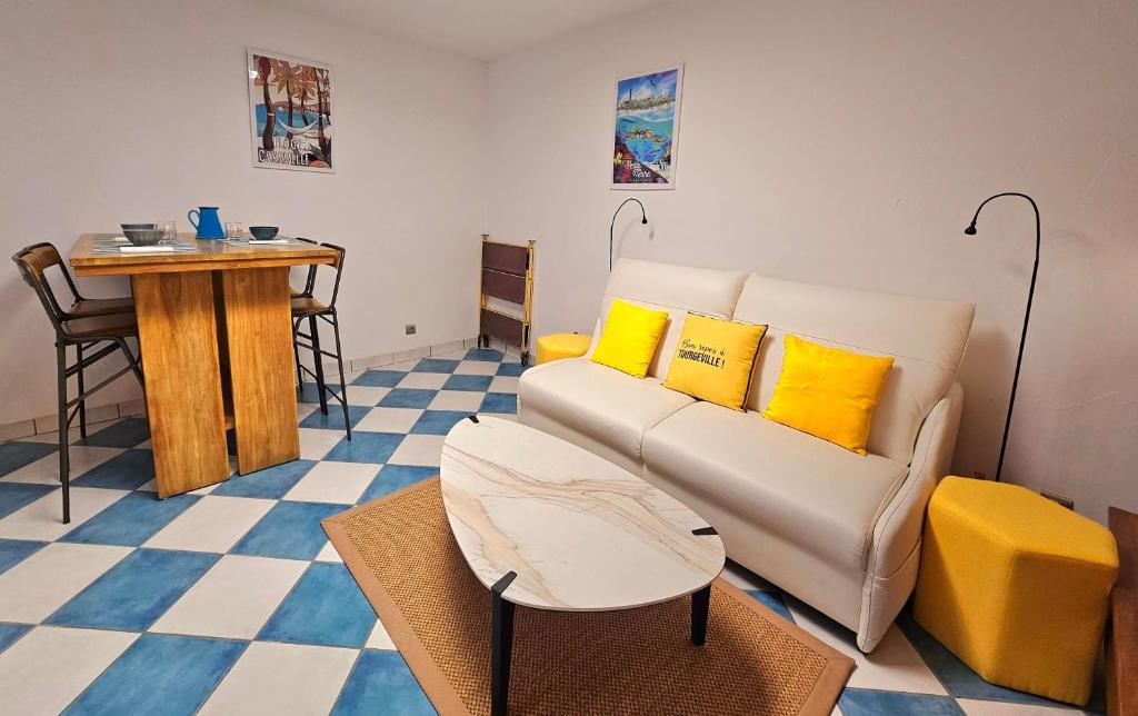 een woonkamer met een bank en een tafel bij Armorial studio cosy 100m plage in Deauville