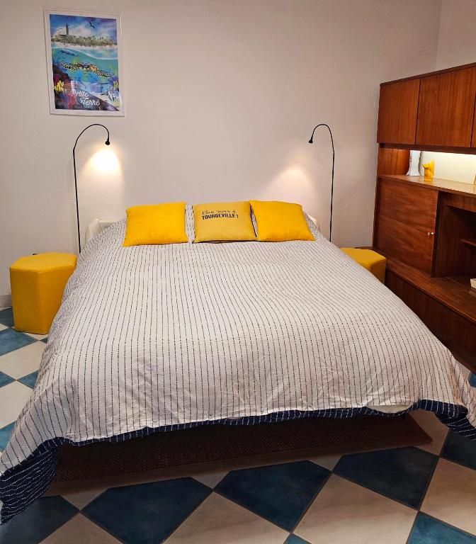 - une chambre avec un lit et 2 oreillers jaunes dans l'établissement Armorial studio cosy 100m plage, à Deauville