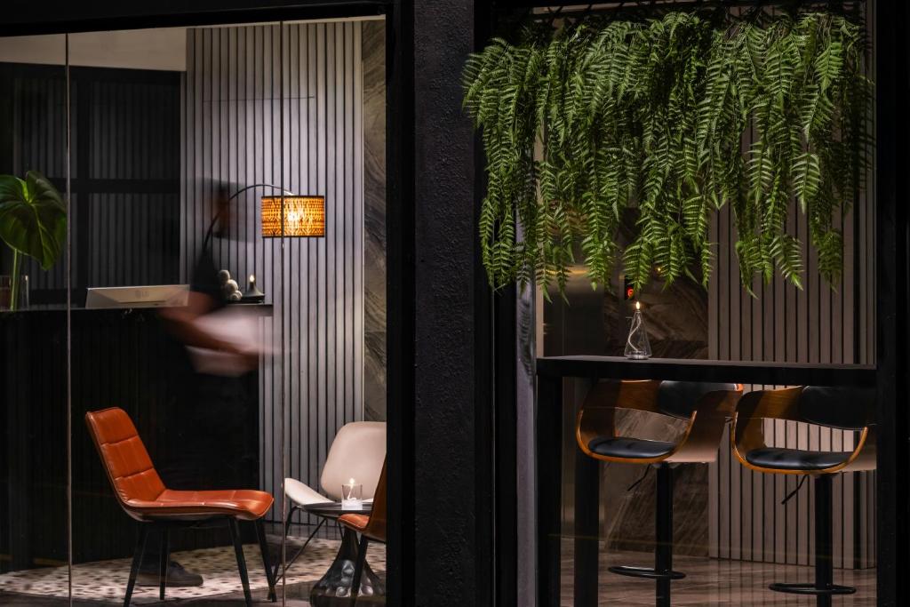 a room with chairs and a table with a plant at BRYQS Hotel KL Sentral in Kuala Lumpur