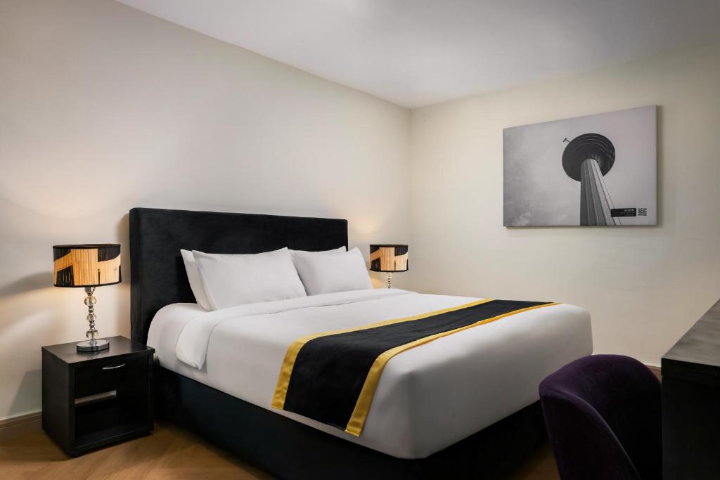 a bedroom with a large bed with two lamps at BRYQS Hotel KL Sentral in Kuala Lumpur