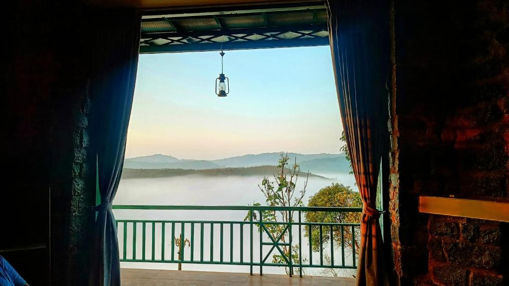 a window with a view of a foggy view at Fifth Estate in Vagamon