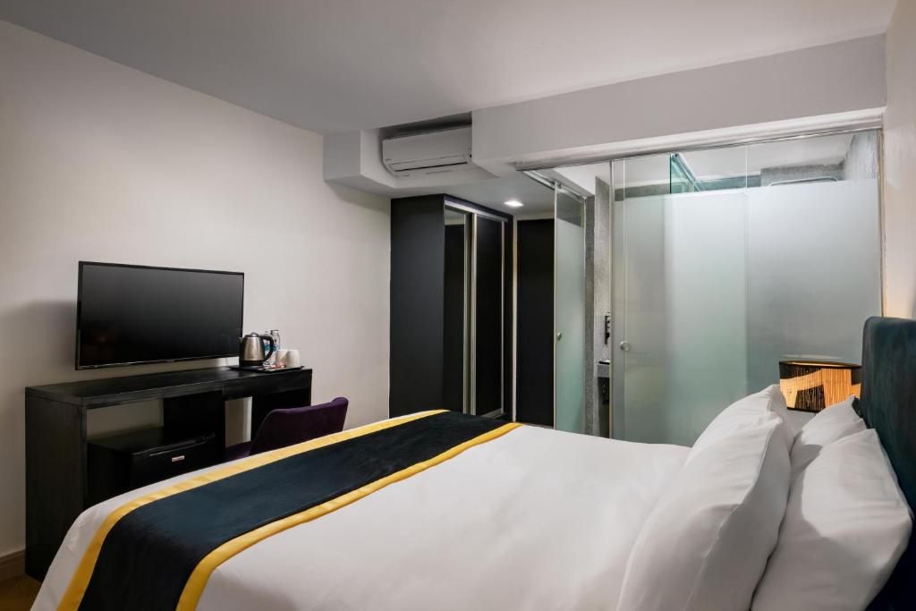 a hotel room with a bed and a tv at BRYQS Hotel KL Sentral in Kuala Lumpur