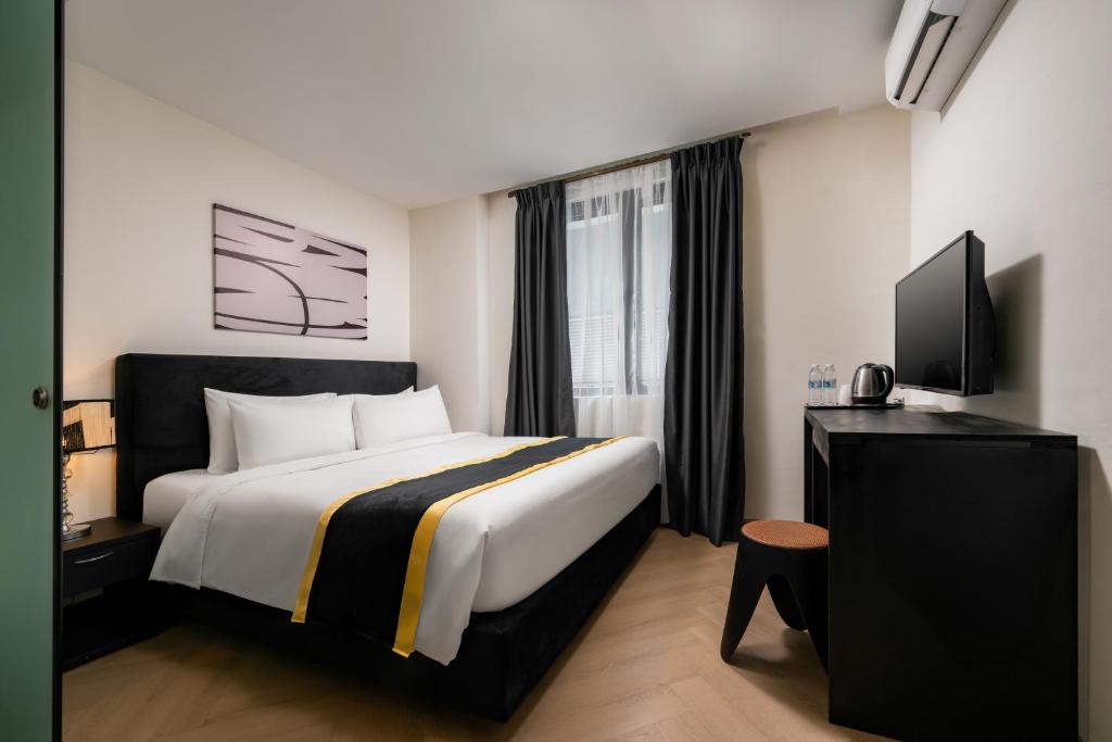 a hotel room with a bed and a flat screen tv at BRYQS Hotel KL Sentral in Kuala Lumpur