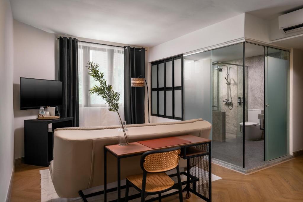 a bathroom with a shower and a table and chairs at BRYQS Hotel KL Sentral in Kuala Lumpur