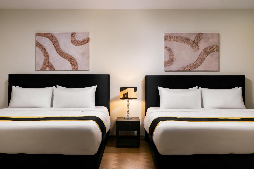 two beds sitting next to each other in a room at BRYQS Hotel KL Sentral in Kuala Lumpur