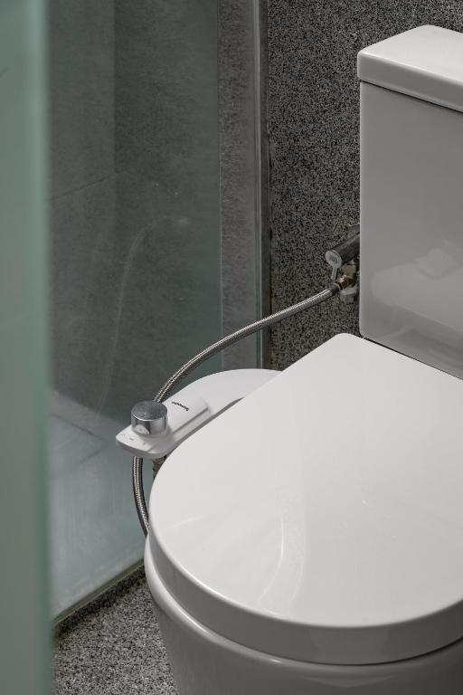 a white toilet in a bathroom with a shower at BRYQS Hotel KL Sentral in Kuala Lumpur