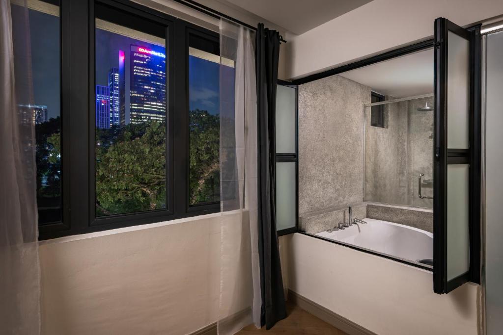 a bathroom with a bath tub and a window at BRYQS Hotel KL Sentral in Kuala Lumpur