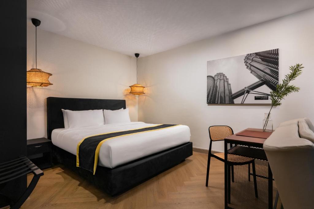 a hotel room with a bed and a table at BRYQS Hotel KL Sentral in Kuala Lumpur