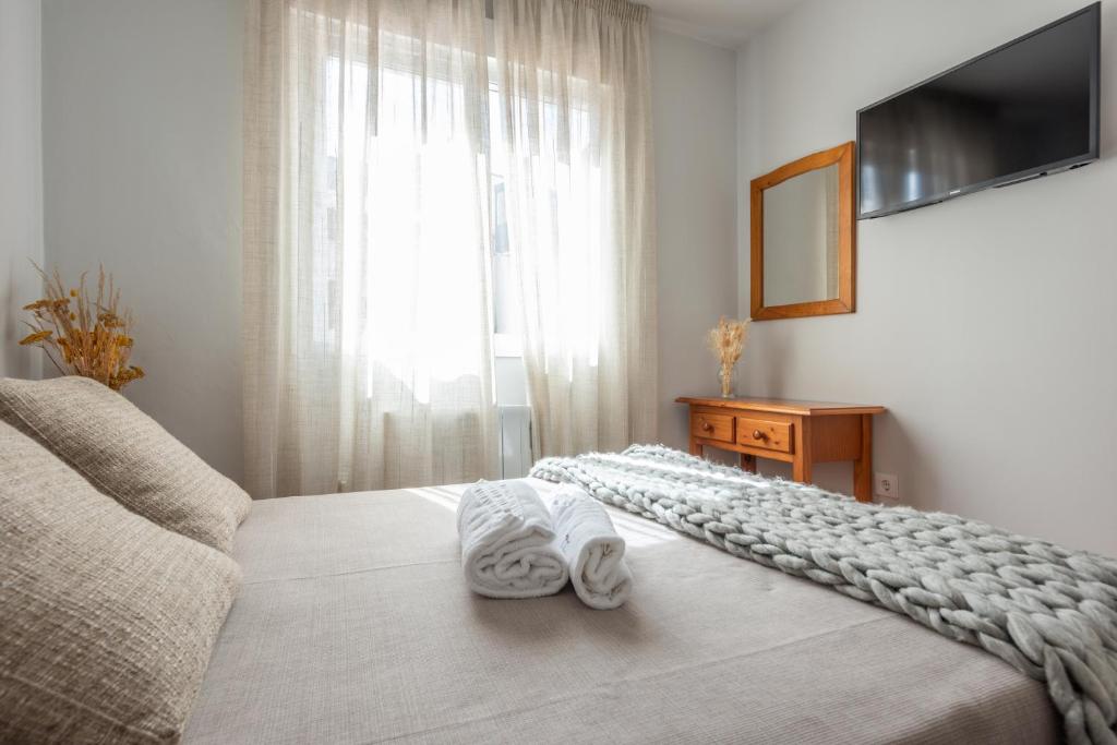 1 dormitorio con 1 cama y ventana grande en Pensión Casa Castelao 31 O Grove, en O Grove
