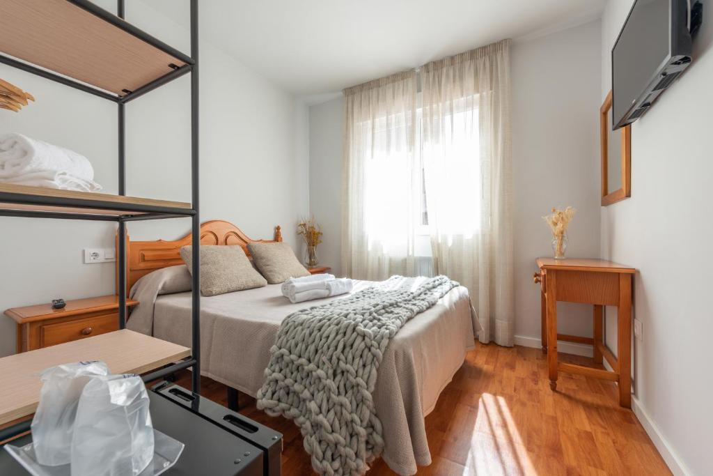un dormitorio con una cama y un espejo en Pensión Casa Castelao 31 O Grove, en O Grove