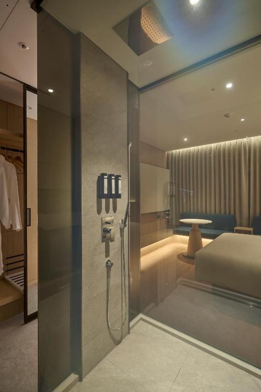 a bathroom with a shower and a bed in a room at Mayfield Hotel Seoul in Seoul