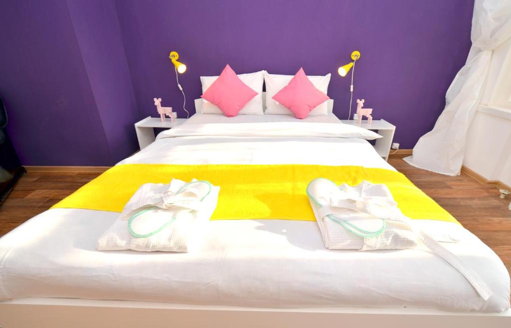 エカテリンブルクにあるAparts Letoのベッドルーム1室(ピンクと黄色のシーツが入った大型ベッド1台付)