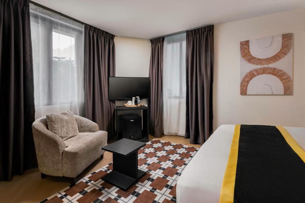a hotel room with a bed and a chair at BRYQS Hotel KL Sentral in Kuala Lumpur