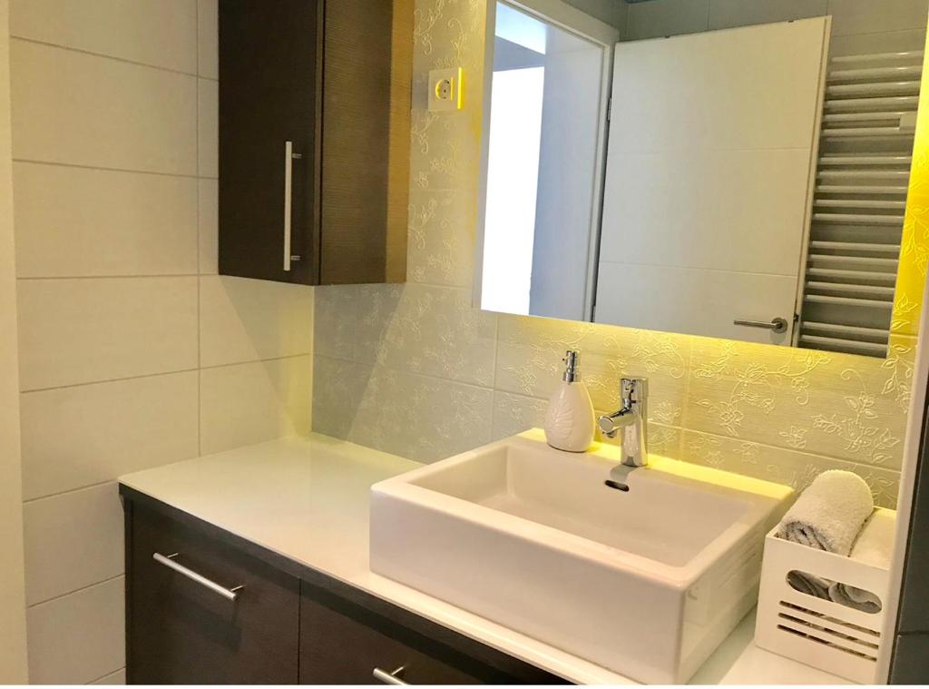 a bathroom with a white sink and a mirror at COZY PLACE NEAR BUS AND RAILWAY STATION with common kitchen, bathroom and toilet in Zagreb