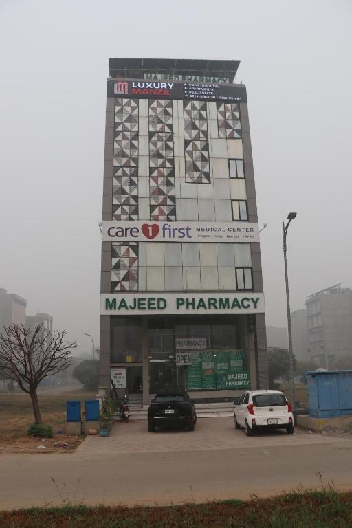 a building with cars parked in a parking lot at Luxury Manzil in Lahore