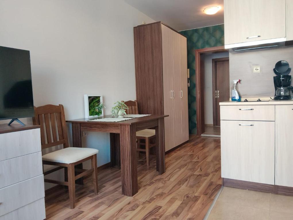 a kitchen with a table and chairs in a room at Studio in Sea Breeze Complex Sveti Vlas in Sveti Vlas