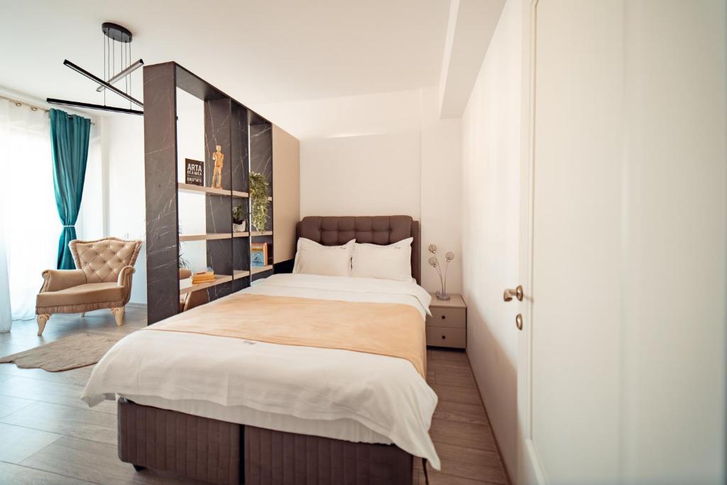 een slaapkamer met een groot bed en een stoel bij COZY Premium Collection - Q Studios Palas Mall Iasi in Iaşi