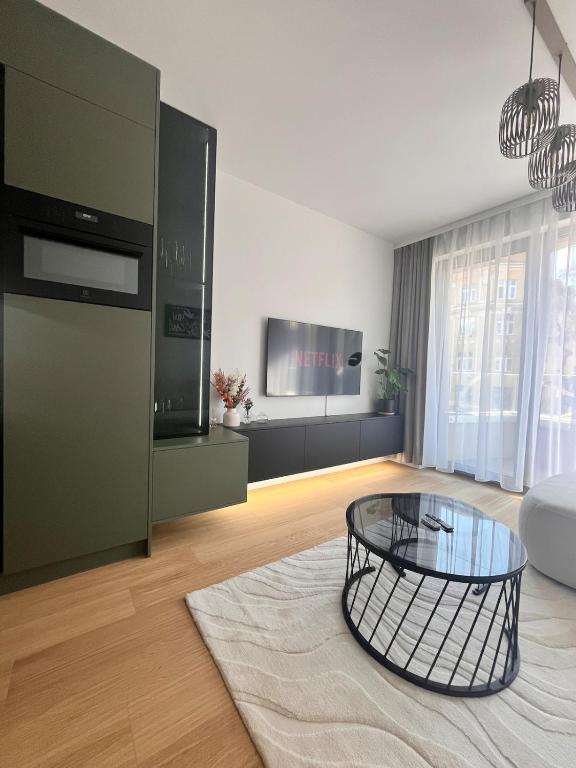 a living room with a coffee table and a tv at VApartment Nova Vajnorska , private parking in Koliba