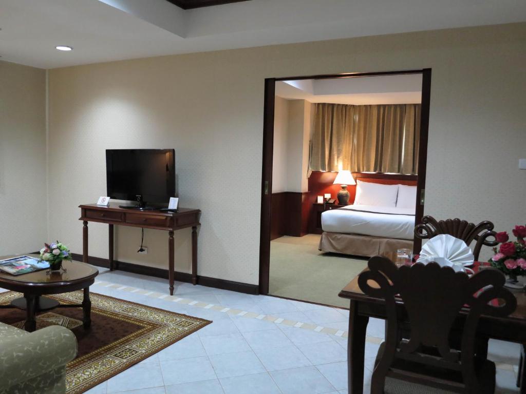 a hotel room with a bed and a mirror at The Grand Sathorn in Bangkok