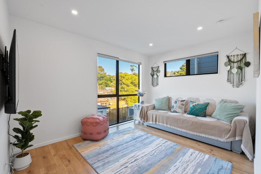 a living room with a couch and a window at Luxury 4 BR Retreat 4 bath with 3 Master Suites and Kids' Playroom in Auckland