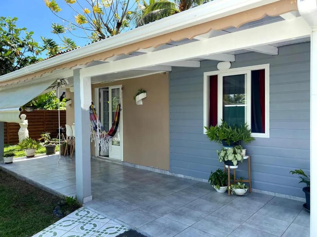 una casa con portico e patio di Bungalow confortable à Sainte-Rose avec jardin privé_222 a Sainte-Rose