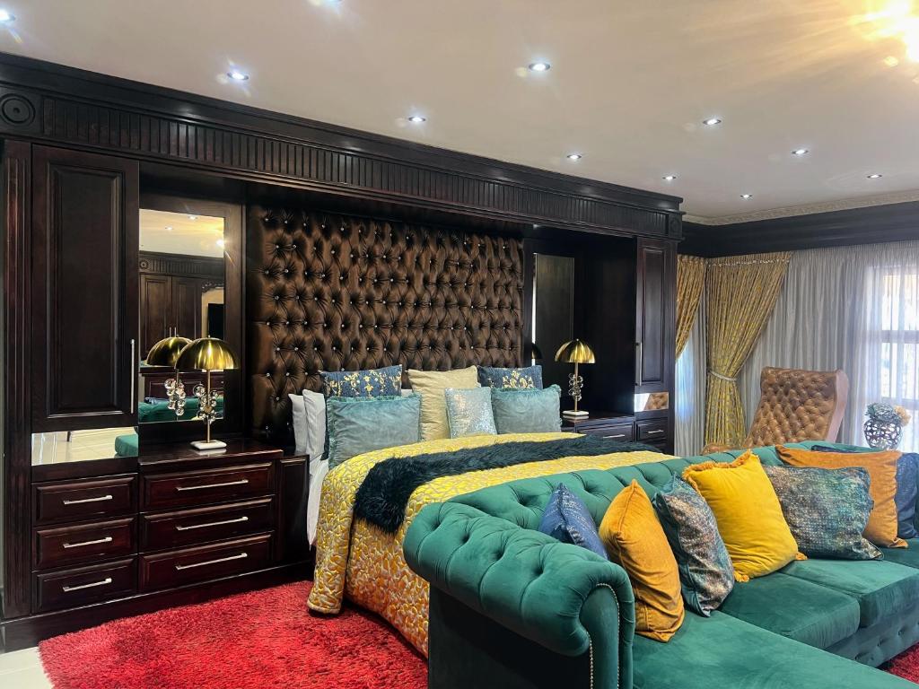 a bedroom with a bed and a green couch at Ambience on N2 Boutique Hotel in Kokstad