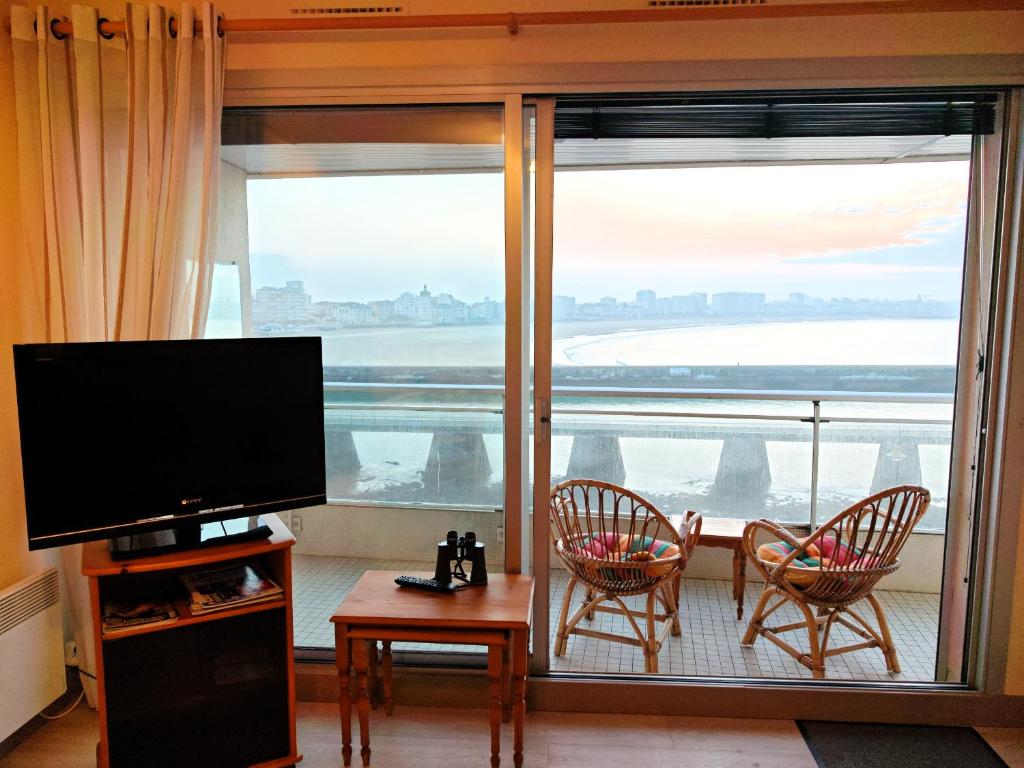 un salon avec une télévision et une grande fenêtre dans l'établissement LE VALPA Face Mer Garage, à Les Sables-dʼOlonne