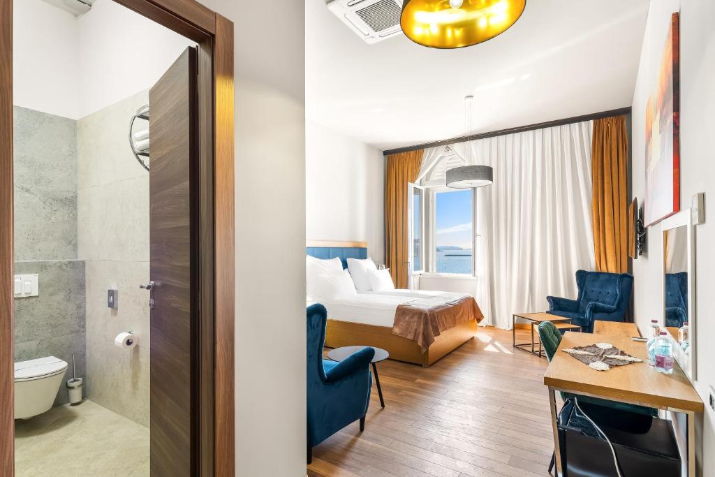 a hotel room with a bed and a bathroom at Hotel Dua Residence in Poreč