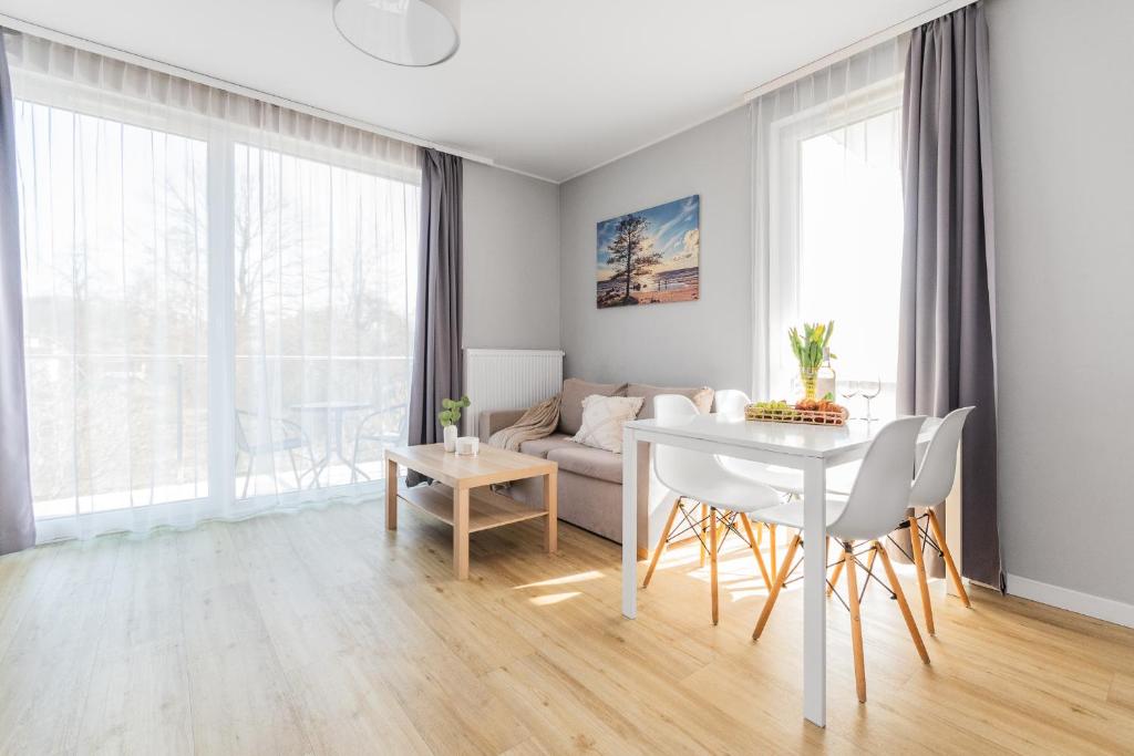 a living room with a table and a couch at APARTAMENTY MIERZEJA - STEGNA FOREST, Przyjazne Zwierzętom, Blisko Lasu, Bezpłatny Meleks in Stegna