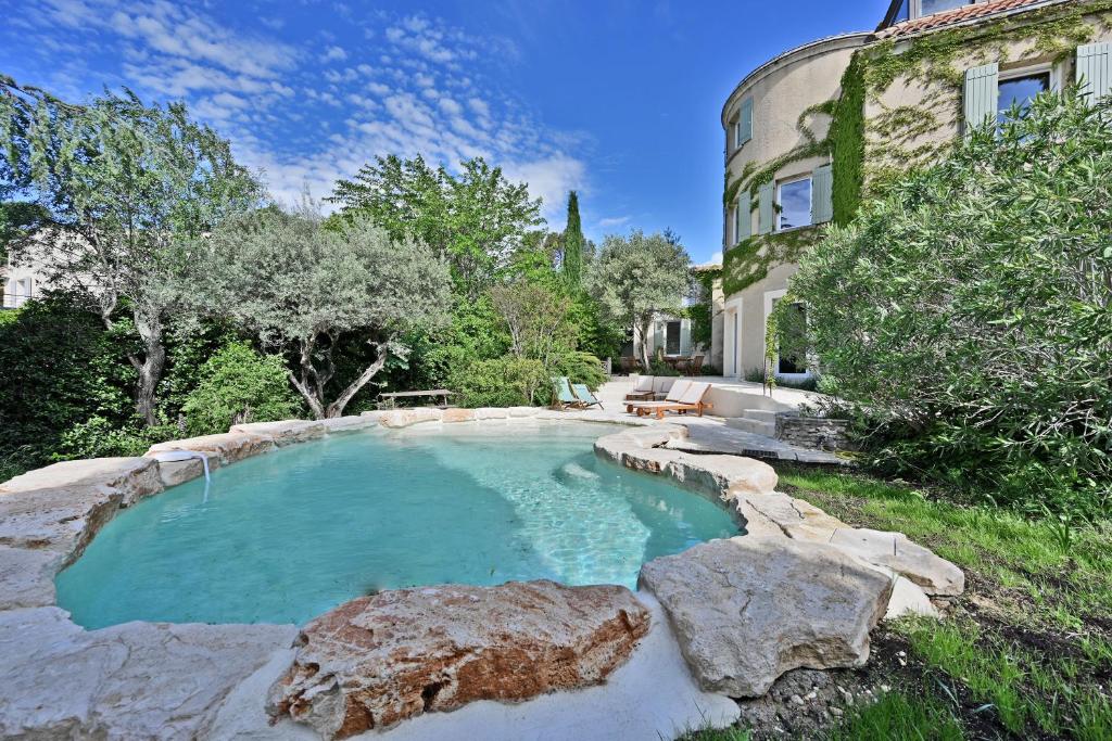 - une piscine avec des rochers en face d'une maison dans l'établissement Villa avec piscine - 5 min d'Avignon, aux Angles (Gard)