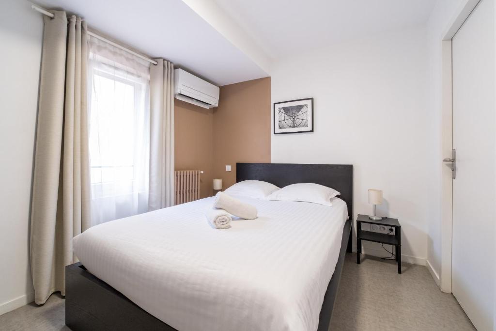 a bedroom with a large white bed with a window at Le 303 Vault - Chambre Climatisée à Jean Jaurès in Toulouse