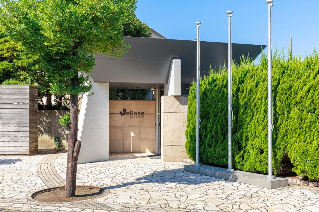 a tree in a courtyard in front of a building at WeBase KAMAKURA in Kamakura