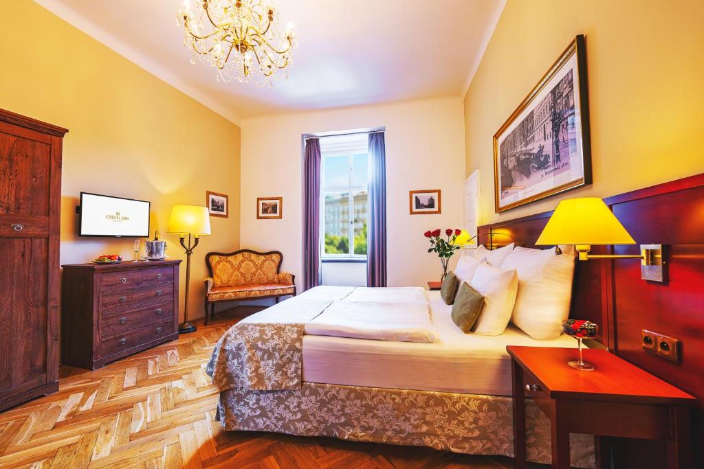 a bedroom with a large bed and a chandelier at Wenceslas Square Hotel - Czech Leading Hotels in Prague