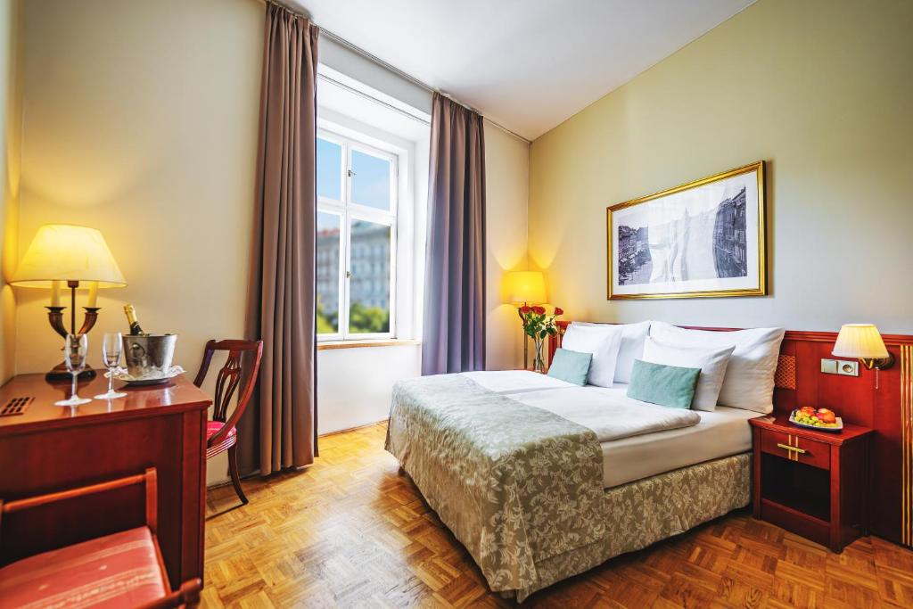 a hotel room with a bed and a desk and a window at Wenceslas Square Hotel - Czech Leading Hotels in Prague