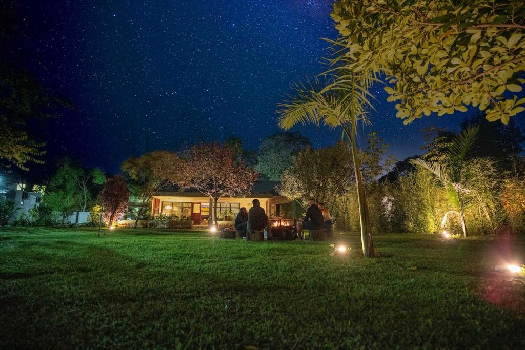 a group of people standing in a yard at night at The Green House in Arusha