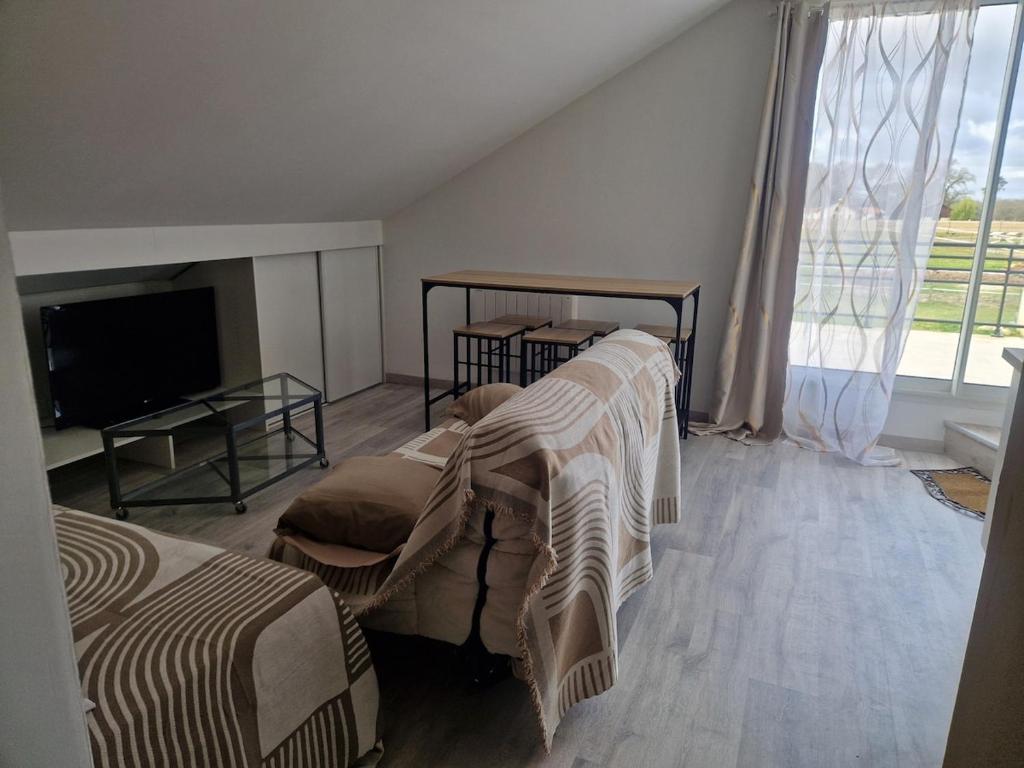 une chambre avec deux lits et une télévision à écran plat dans l'établissement Hebergement et Etapes equestres, à Bégaar