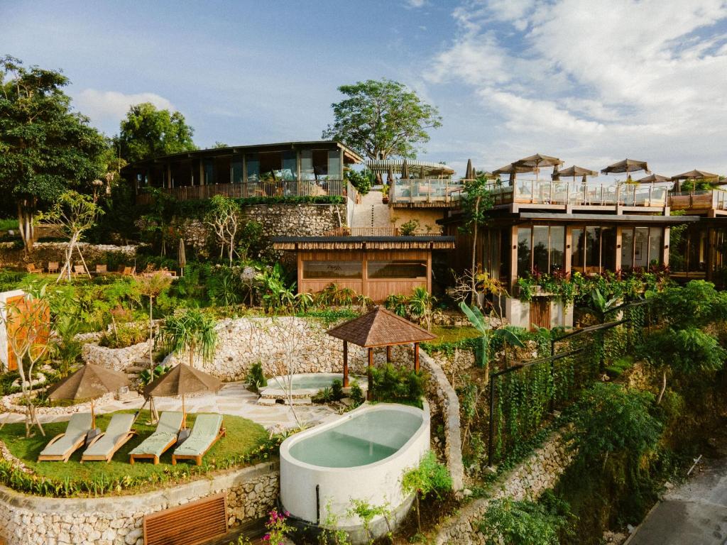 a house with a bath tub in a garden at Grün Resort Uluwatu in Uluwatu