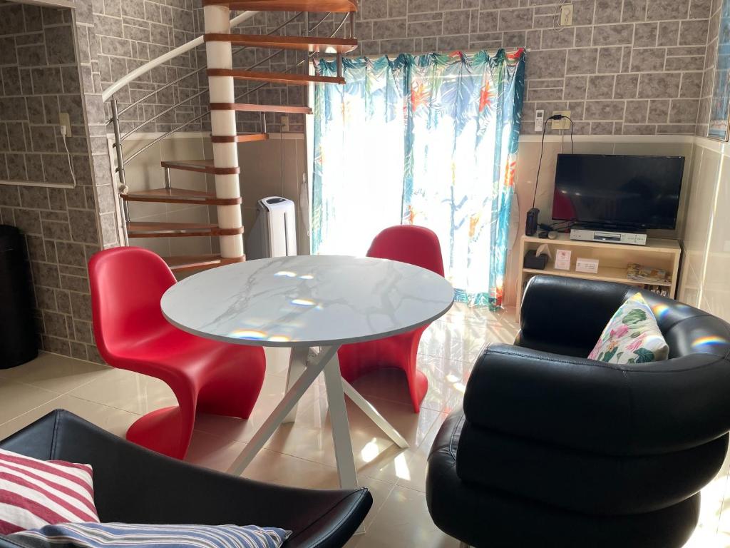 a living room with a white table and red chairs at Elegance Kukou Minami B - Vacation STAY 12934 in Miyazaki