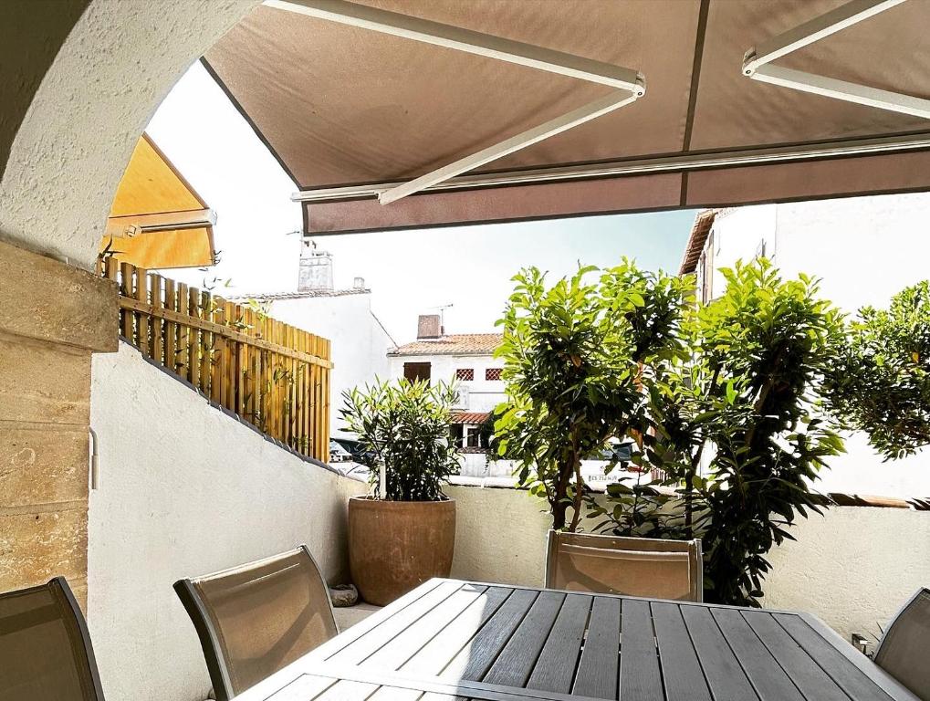 d'une table et de chaises sur un balcon orné de plantes. dans l'établissement Le 45- La Sauvagine, Appartement avec grande terrasse, 6 Couchages, 2 chambres, 3min de la plage, à Saintes-Maries-de-la-Mer