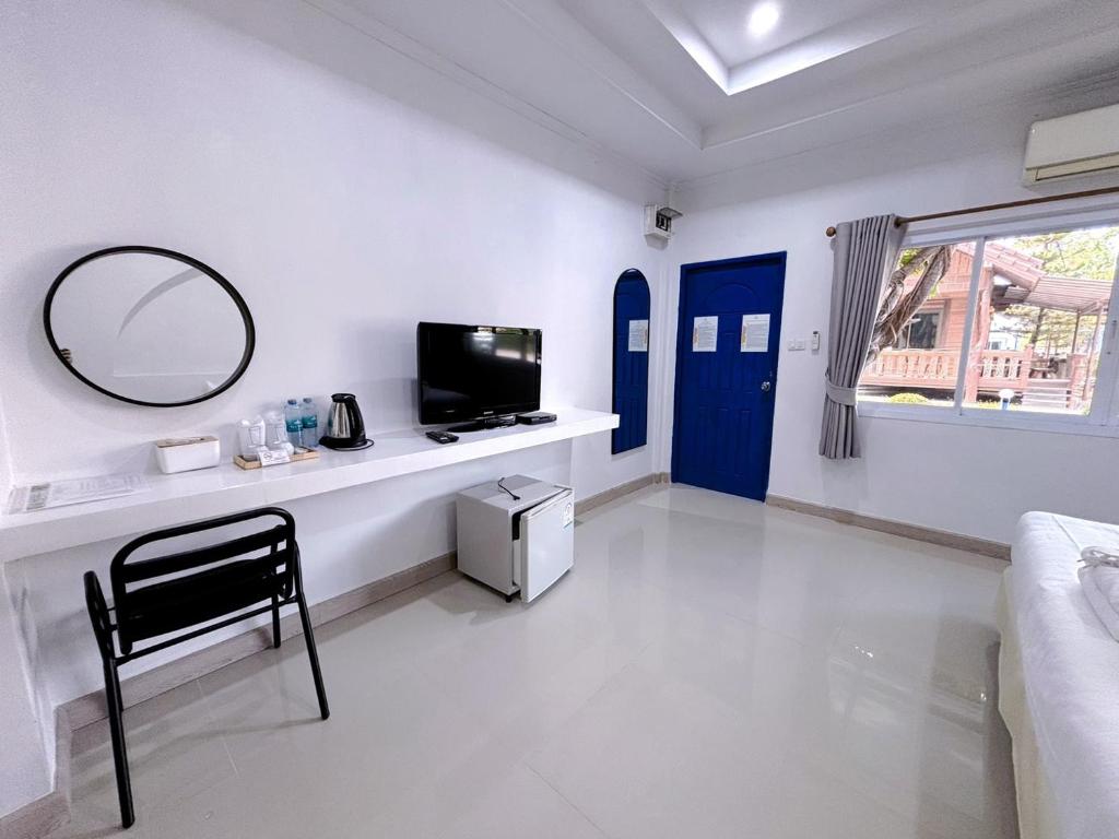 a white living room with a mirror and a table at Sky View Resort Buriram in Buriram