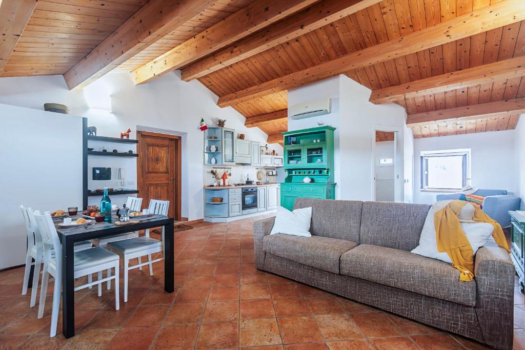 a living room with a couch and a table at Una Mansarda Nell'isola - Happy Rentals in La Maddalena