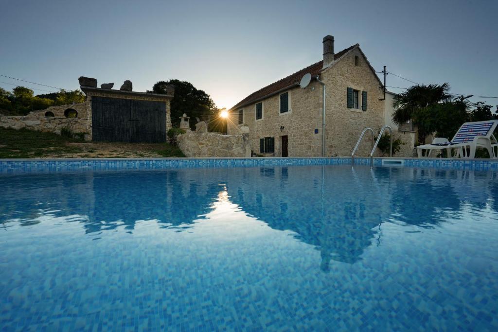 a large swimming pool in front of a building at Holiday Home Leptir in Drniš